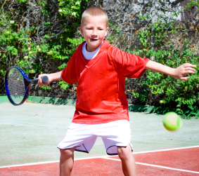 Young child playing tennis